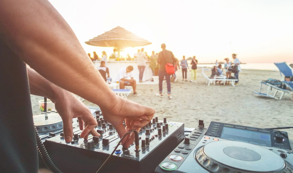 dj mixing at sunset beach party in ibiza